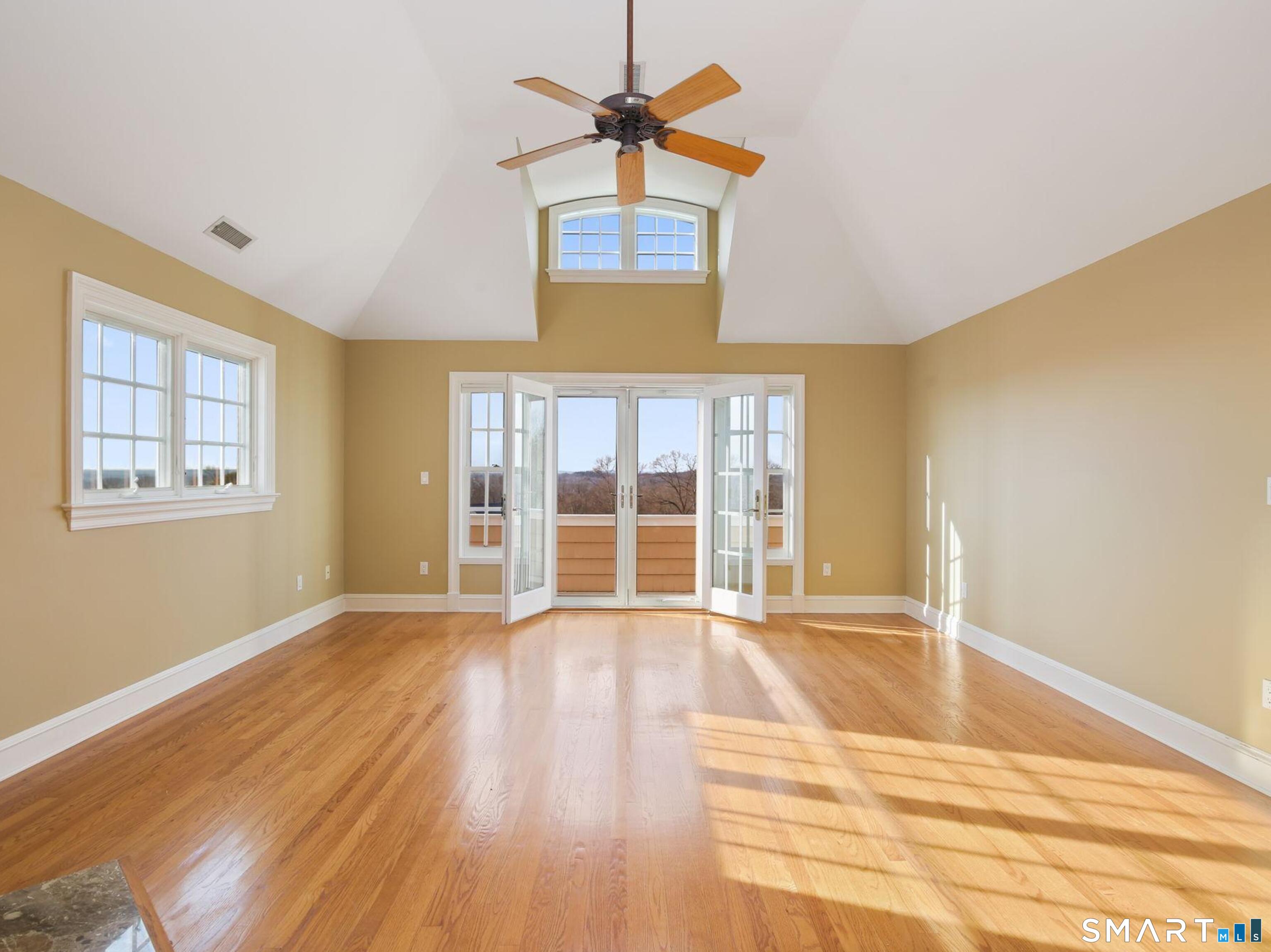 7 Long Meadow Lane Redding, CT 06896 - Photo 35 of 38 Spacious primary bedroom featuring a fireplace, vaulted ceilings, and excellent natural light and private balcony.