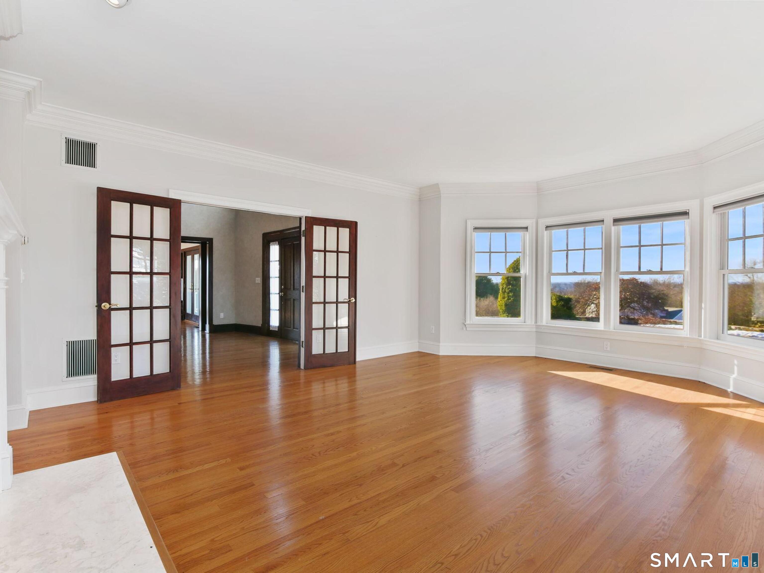 7 Long Meadow Lane Redding, CT 06896 - Photo 10 of 38 a view of an empty room with wooden floor and a window