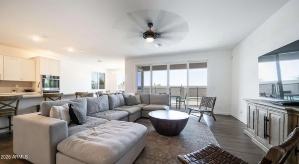 a living room with furniture a table and a large window
