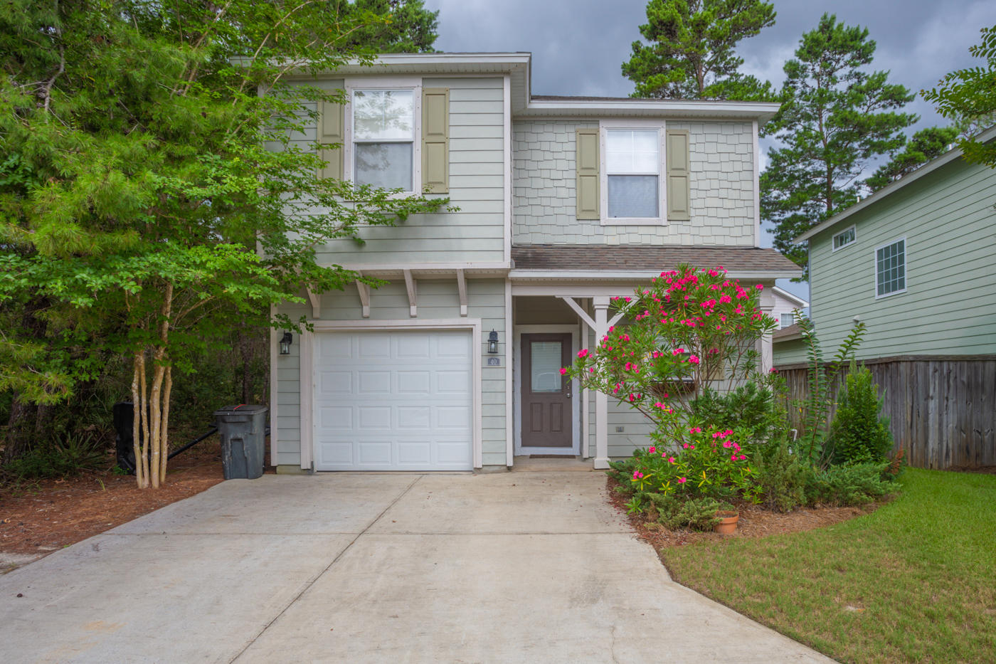 front view of house with potted plants and a bench