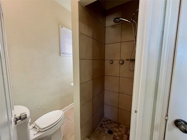 a bathroom with a toilet and a shower