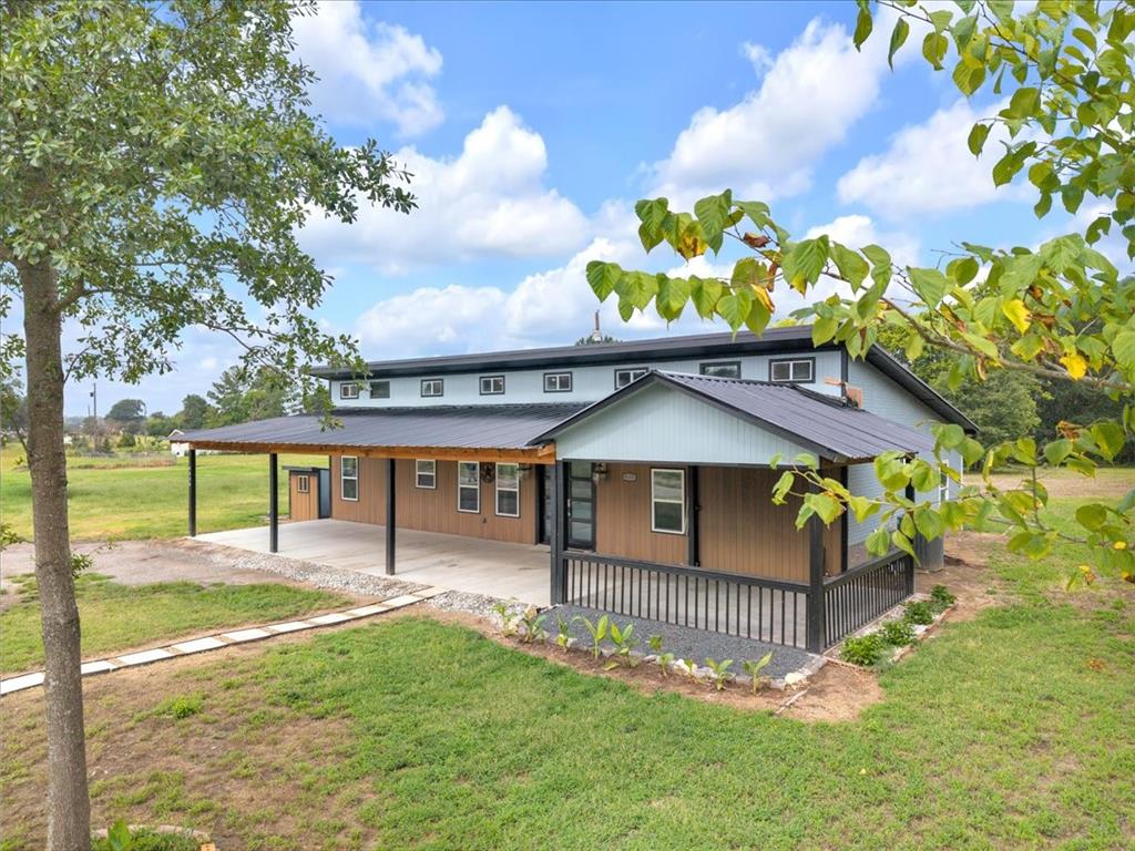 4120 Benjamin Road Caney City, TX 75148 - Photo 1 of 36 Modern farmhouse exterior featuring an expansive covered porch, metal roof, and durable siding