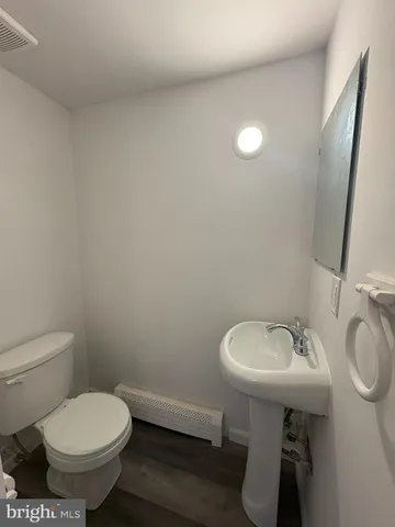 a bathroom with a sink toilet and a mirror