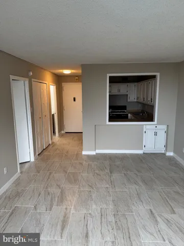 a view of an empty room with a fireplace and cabinet