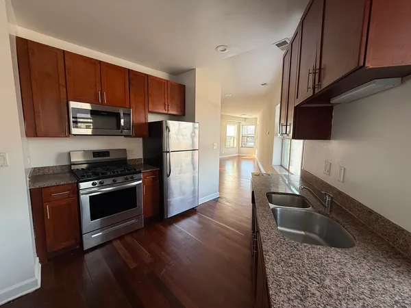 a kitchen with granite countertop a refrigerator stove and microwave