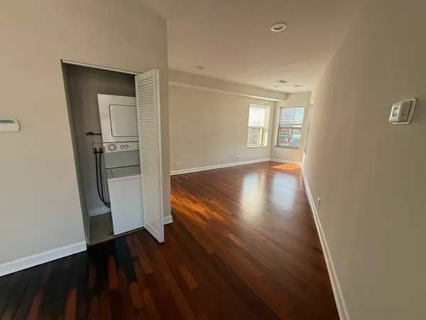 a view of empty room with wooden floor