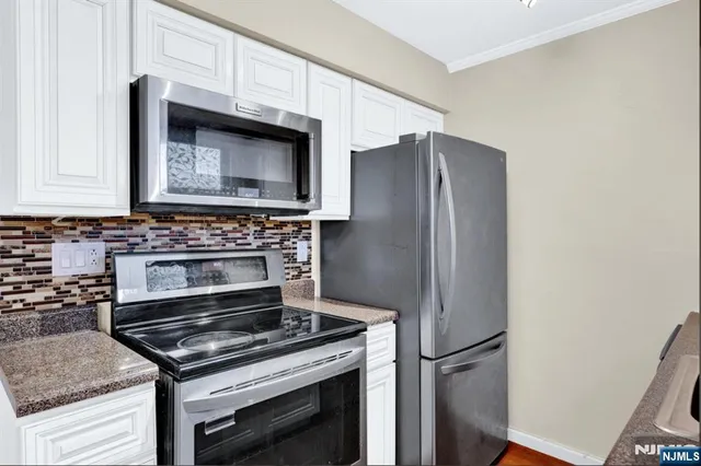a kitchen with granite countertop a stove and a microwave