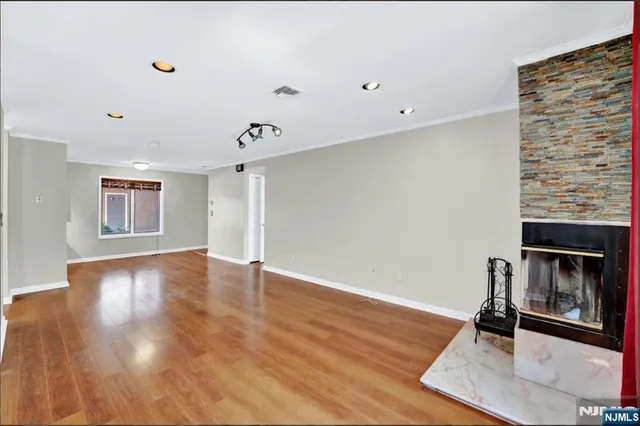 a view of a livingroom with wooden floor and a ceiling fan