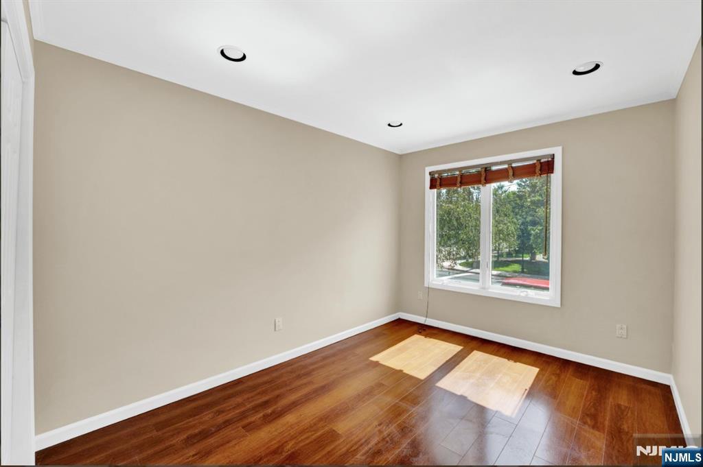 105 State Street, Unit 1B Hackensack, NJ 07601 - Photo 18 of 22 an empty room with wooden floor and windows
