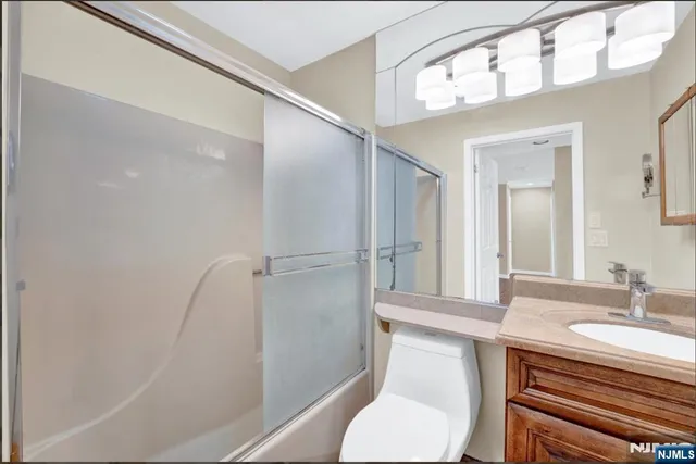 a bathroom with a sink a toilet a mirror and shower