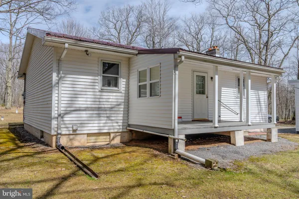 a view of house with backyard and chairs