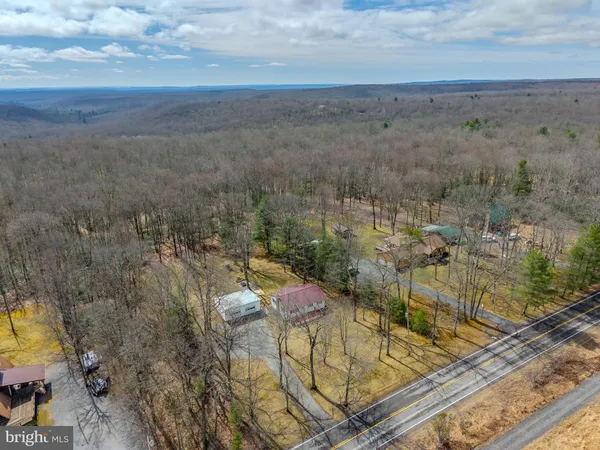 a view of a house with large trees next to a road