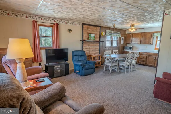 a living room with furniture a flat screen tv and a window