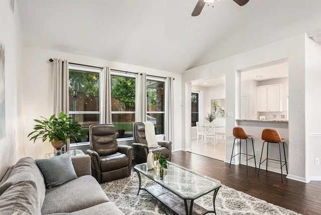 a living room with furniture a wooden floor and next to a window
