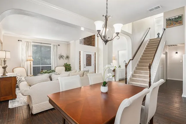 a view of a dining room with furniture a chandelier and wooden floor