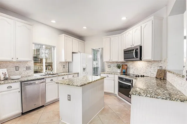 a kitchen with cabinets appliances a sink and a counter top space