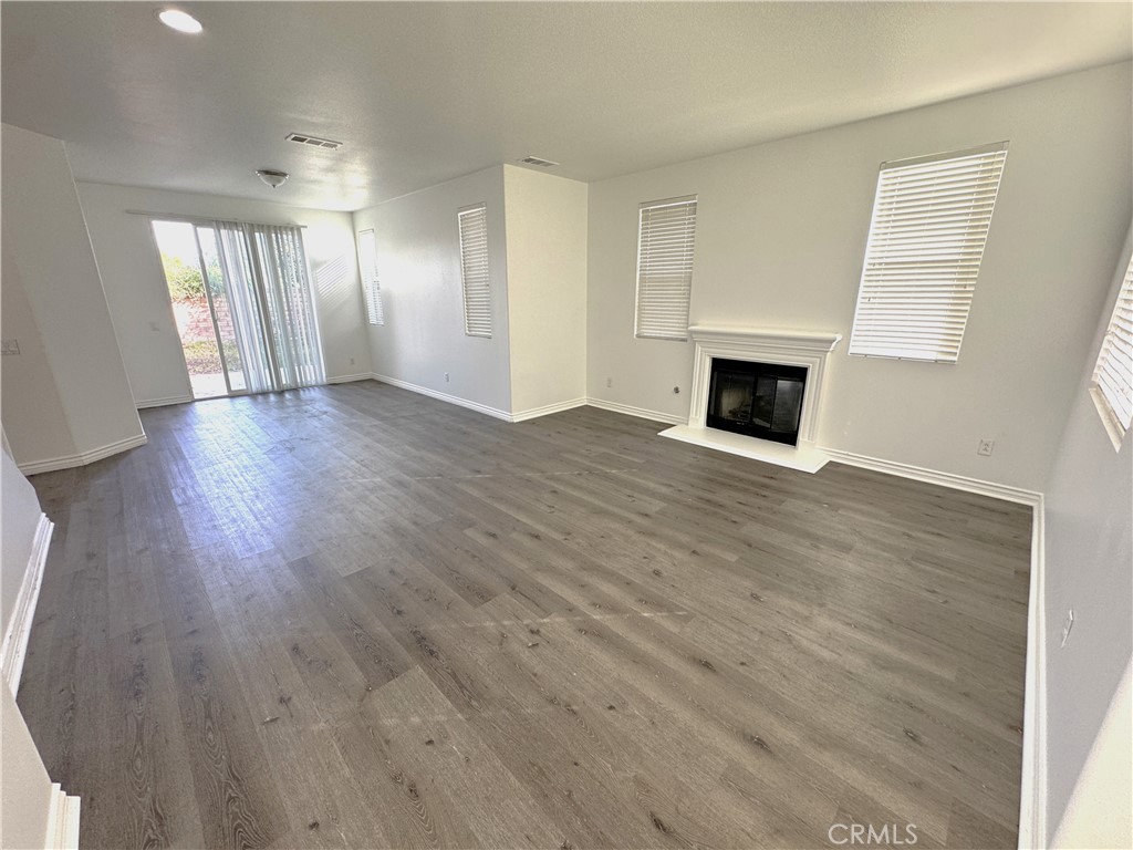 8240 Chamberlain Lane Reseda, CA 91335 - Photo 3 of 23 a view of an empty room with wooden floor and fireplace