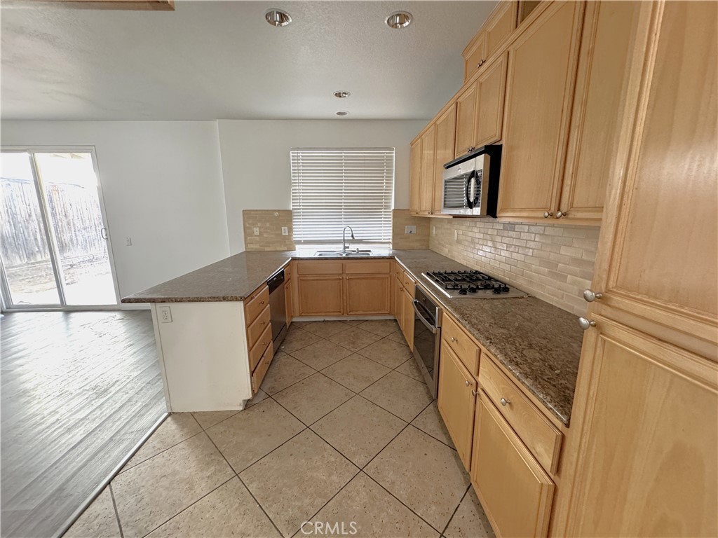 8240 Chamberlain Lane Reseda, CA 91335 - Photo 8 of 23 a kitchen with stainless steel appliances granite countertop a sink and a stove
