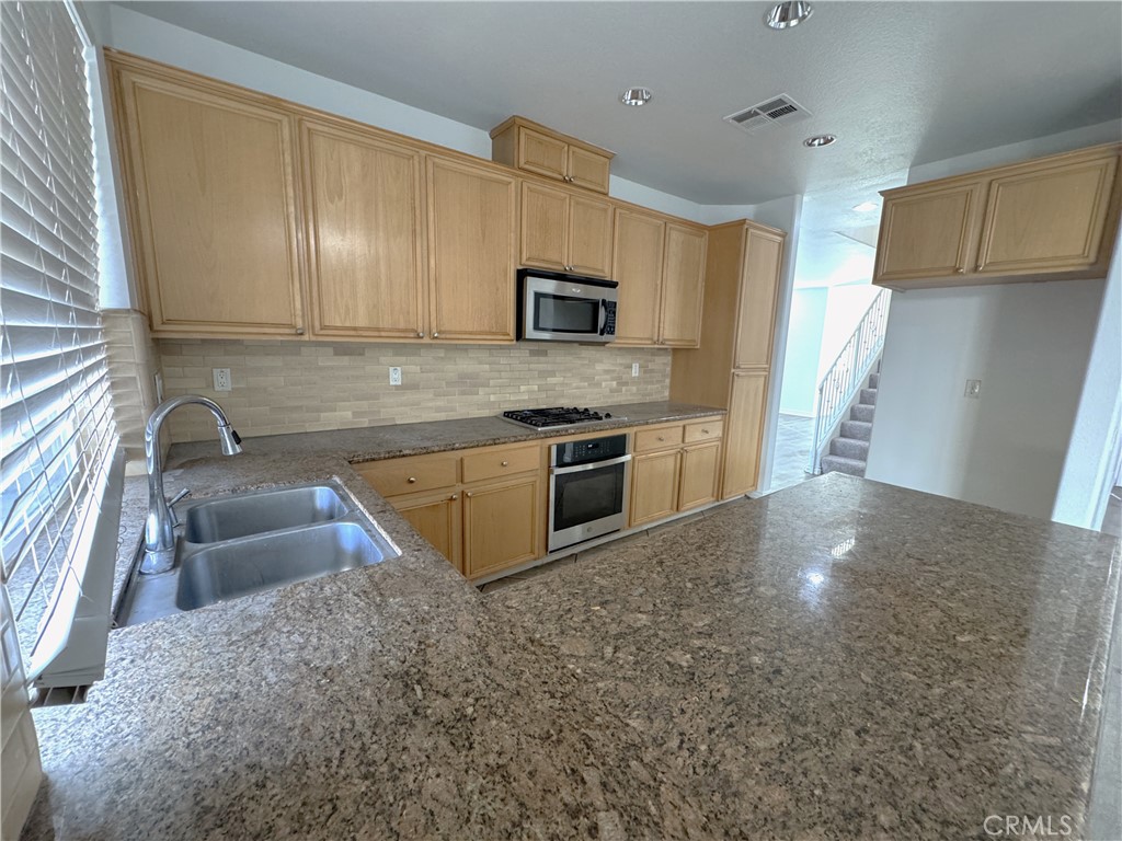 8240 Chamberlain Lane Reseda, CA 91335 - Photo 9 of 23 a kitchen with stainless steel appliances granite countertop a sink and a stove top oven