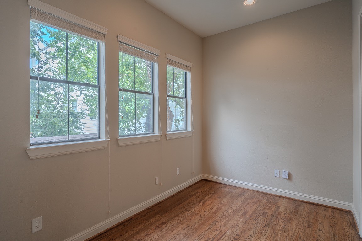 5213 Eigel Street, Unit B Houston, TX 77007 - Photo 12 of 28 a view of an empty room with wooden floor and a window