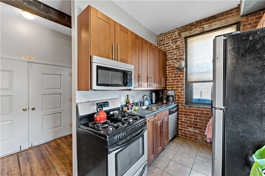 131 Beam Way Pittsburgh, PA 15211 - Photo 19 of 50 a kitchen with stainless steel appliances a stove a sink and a microwave