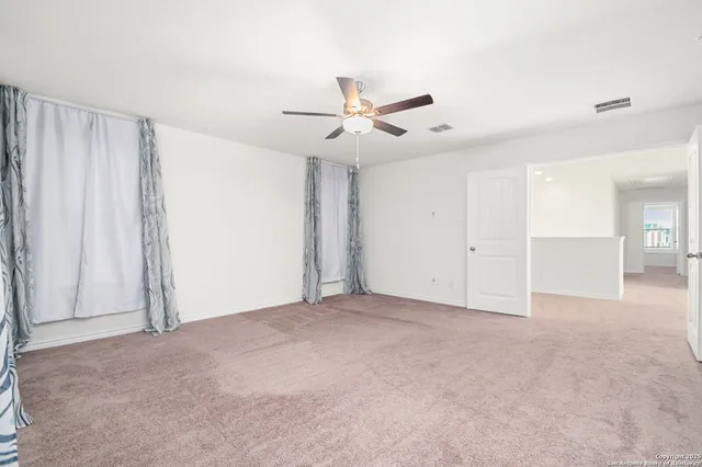 an empty room with closet and a ceiling fan