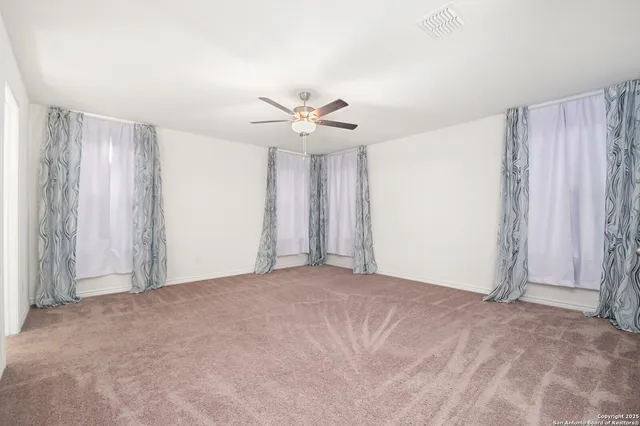 a view of a livingroom with a ceiling fan and window
