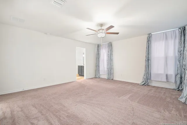 an empty room with a ceiling fan and a window
