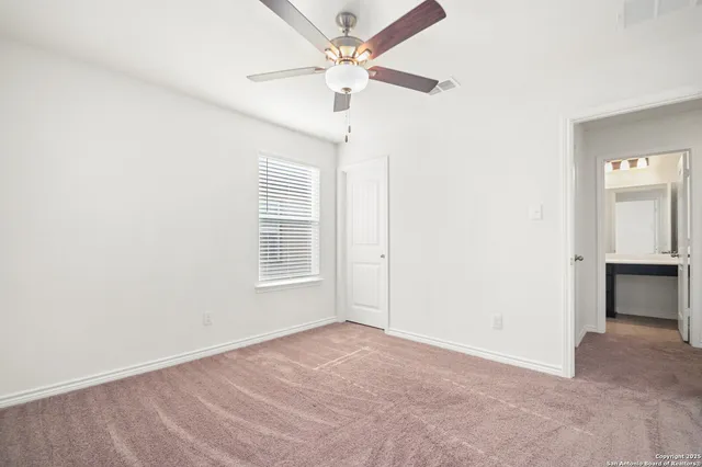 an empty room with fan and windows