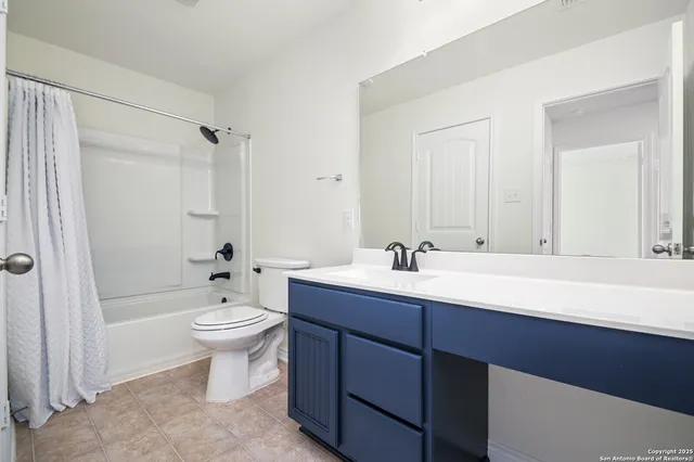 a bathroom with a toilet a sink a mirror a bathtub and vanity