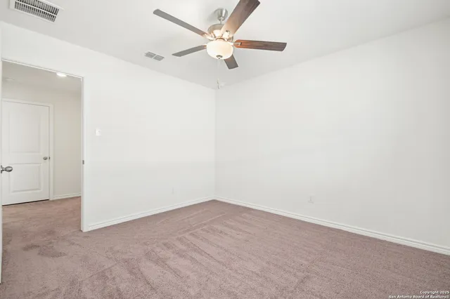 an empty room with a fan and a ceiling fan