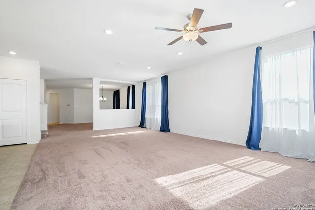a view of a livingroom with a ceiling fan and window
