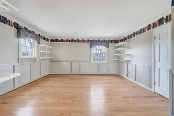 a large white kitchen with wooden floors and a large window