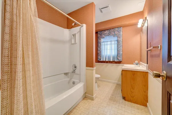 a view of backyard with large trees and wooden fence