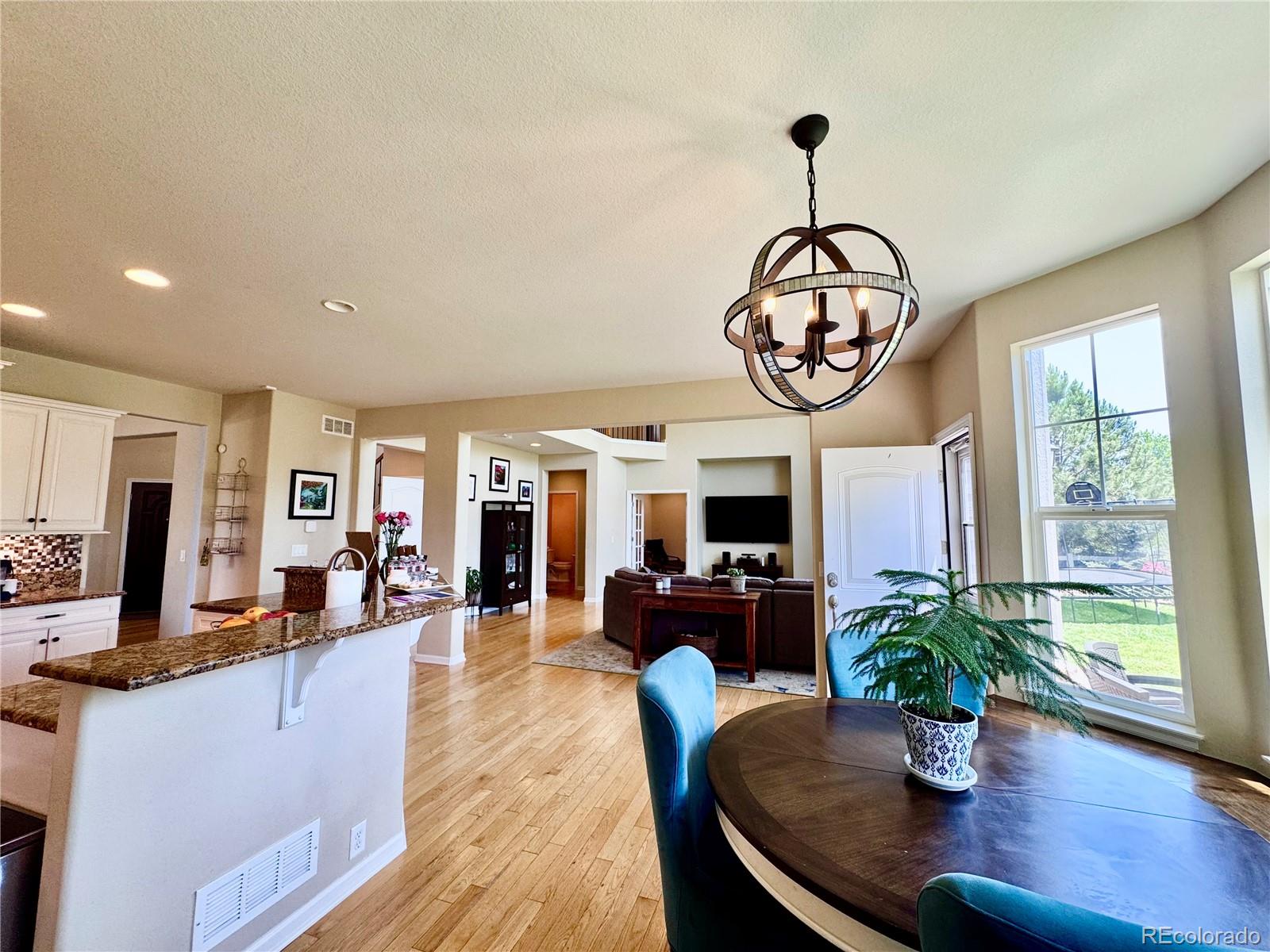 2896 Gemini Loop Broomfield, CO 80023 - Photo 15 of 49 a view of a dining room with furniture a chandelier and wooden floor