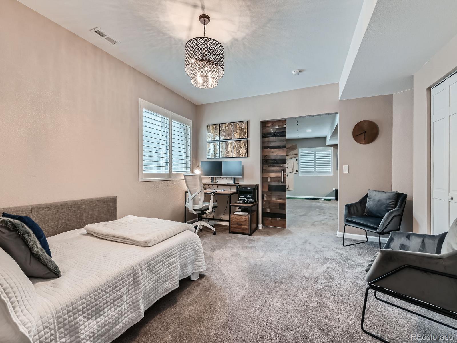 2896 Gemini Loop Broomfield, CO 80023 - Photo 38 of 49 a bedroom with a bed and a chandelier