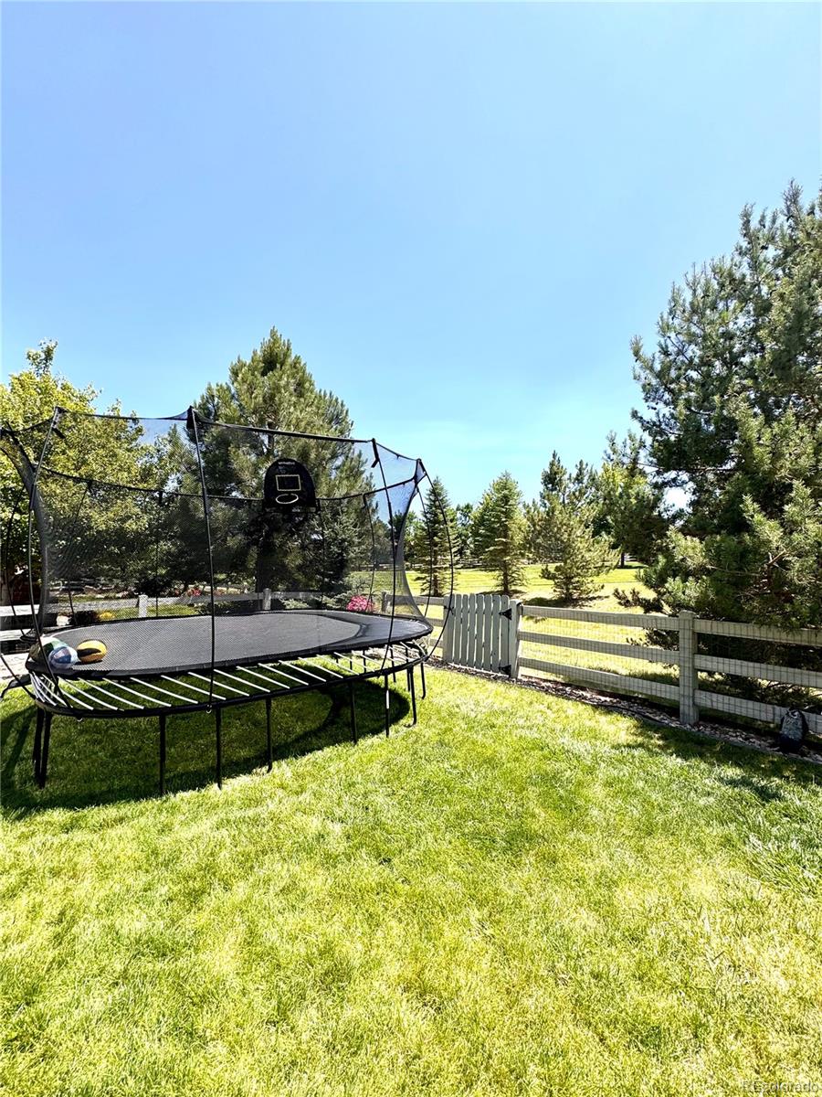 2896 Gemini Loop Broomfield, CO 80023 - Photo 47 of 49 a view of a swimming pool with a bench and trees in the background