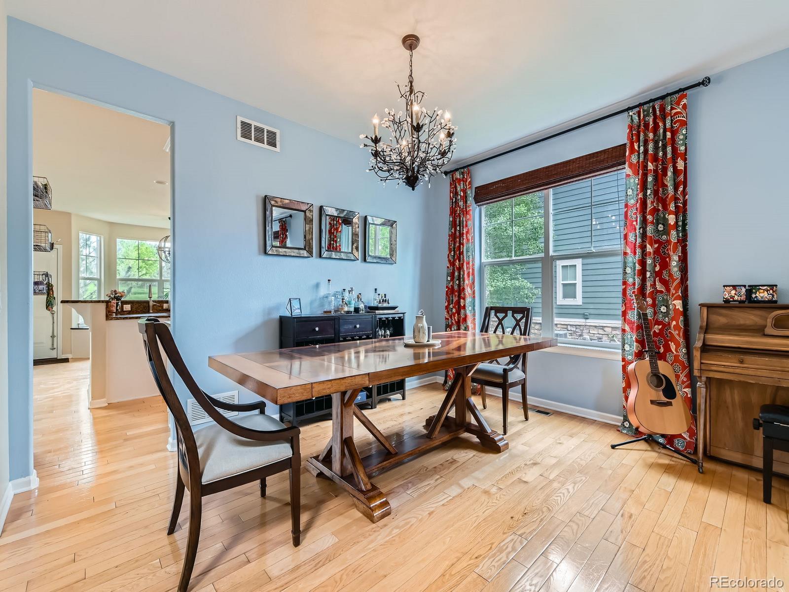 2896 Gemini Loop Broomfield, CO 80023 - Photo 7 of 49 a dining room with furniture a chandelier and wooden floor
