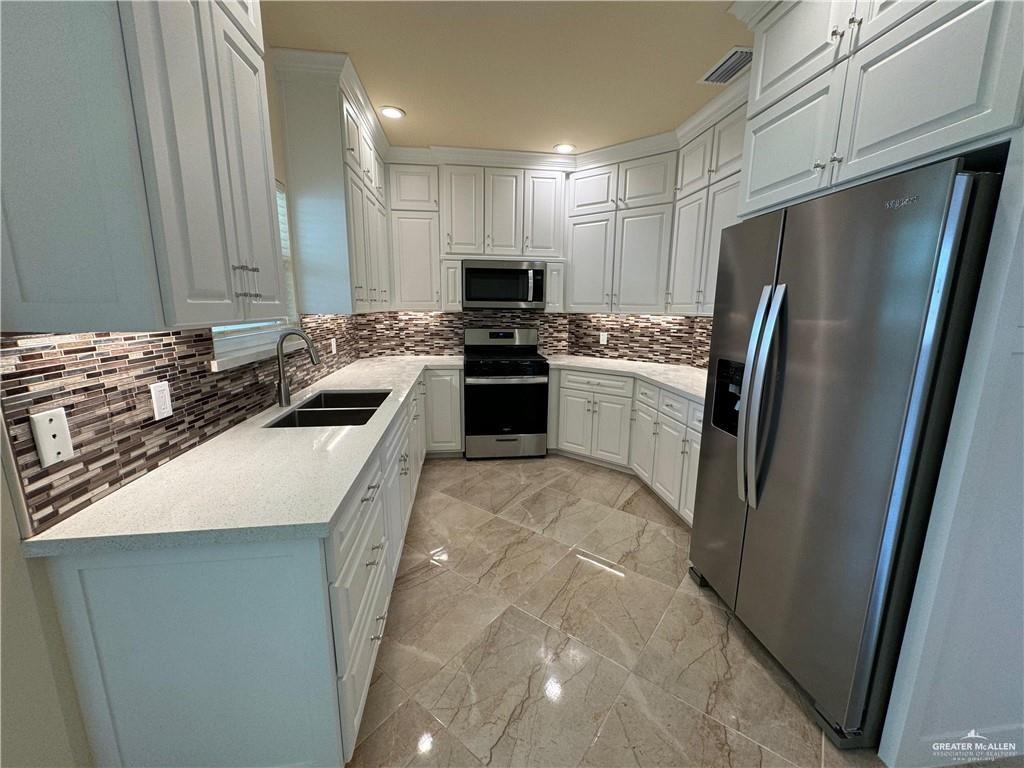 1114 North 20th Street McAllen, TX 78501 - Photo 4 of 27 a kitchen with stainless steel appliances granite countertop a refrigerator a stove and a sink