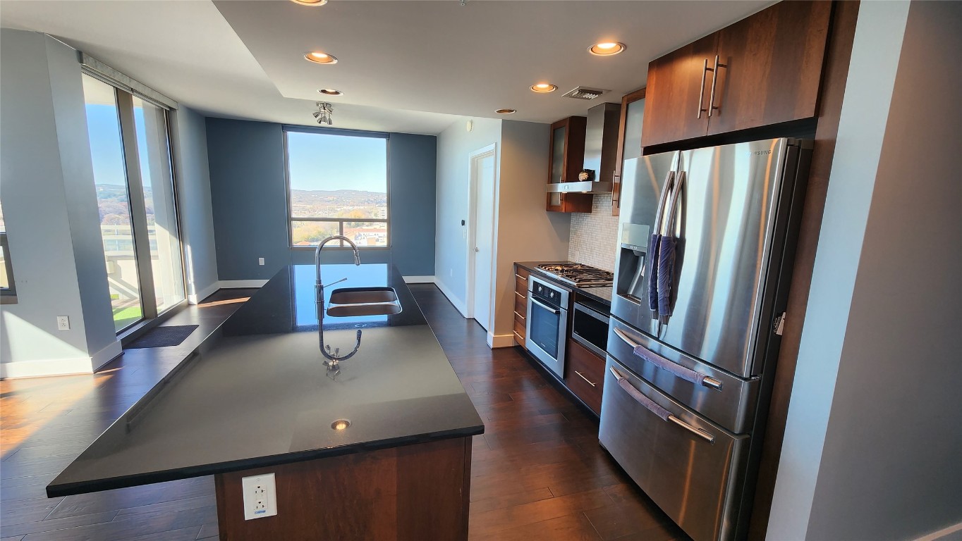 300 Bowie Street, Unit 1305 Austin, TX 78703 - Photo 9 of 38 a kitchen with stainless steel appliances a refrigerator a sink a stove cabinets and wooden floor