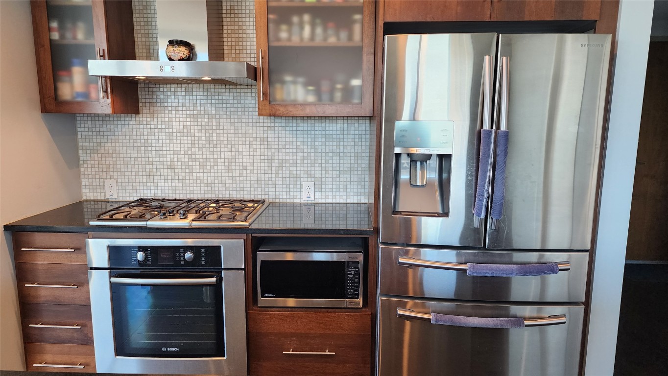 300 Bowie Street, Unit 1305 Austin, TX 78703 - Photo 10 of 38 a kitchen with granite countertop stainless steel appliances and wooden cabinets
