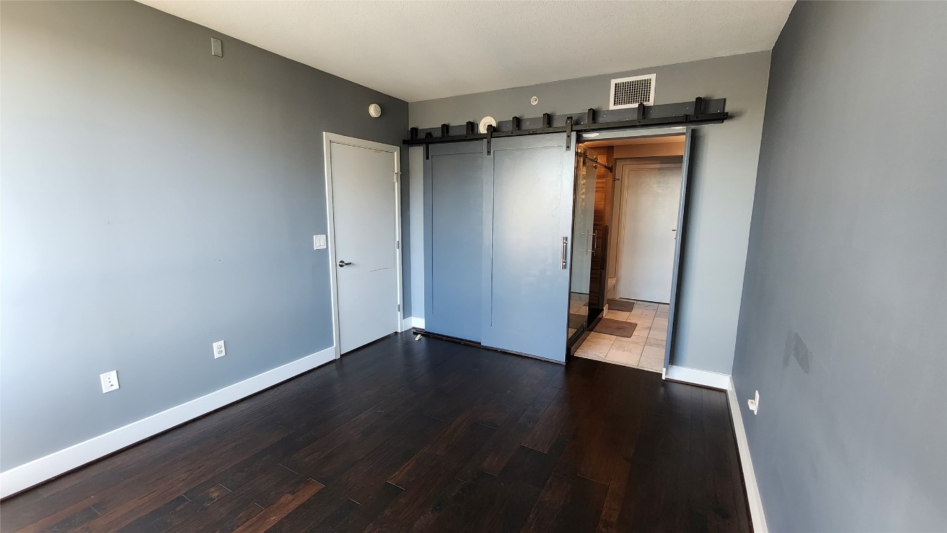 300 Bowie Street, Unit 1305 Austin, TX 78703 - Photo 15 of 38 a view of an empty room with wooden floor and a window