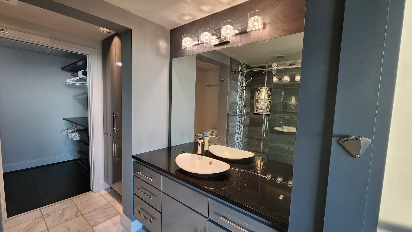 300 Bowie Street, Unit 1305 Austin, TX 78703 - Photo 20 of 38 a bathroom with a granite countertop sink and a mirror