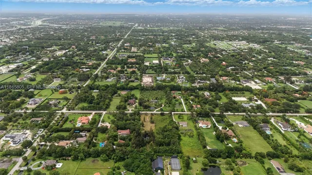 an aerial view of residential houses with outdoor space and trees