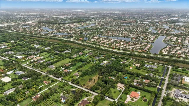 an aerial view of residential houses with outdoor space and trees