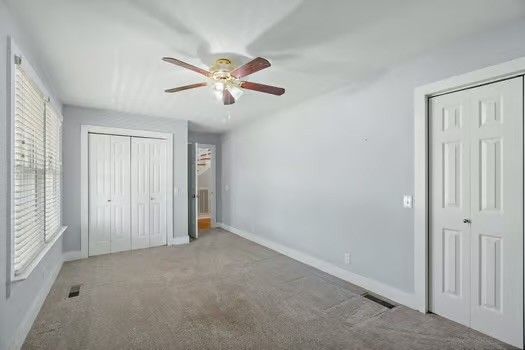 a view of empty room with chandelier fan