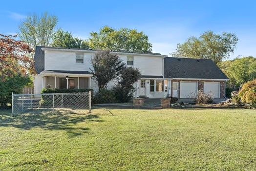 a house that has a big yard with plants and trees in front of it