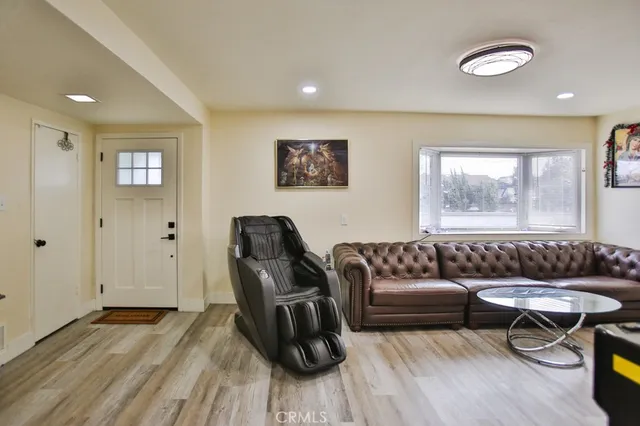 a living room with furniture and a wooden floor