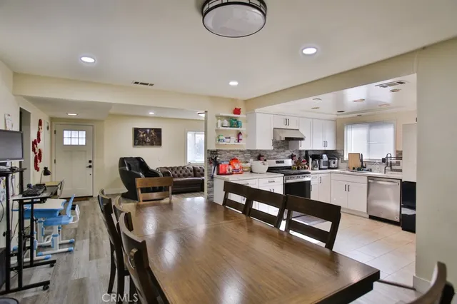 a living room with furniture kitchen view and a wooden floor