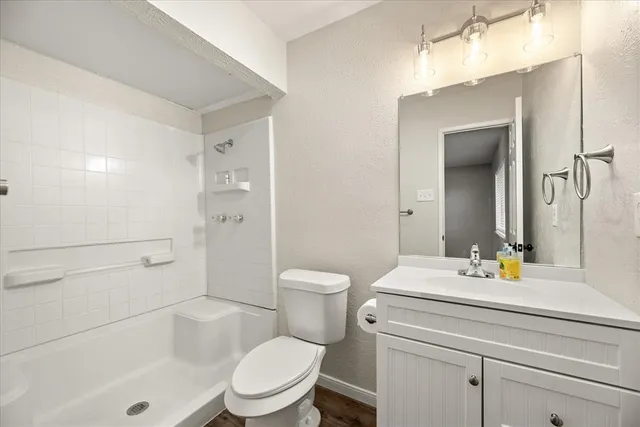a bathroom with a sink a toilet and shower